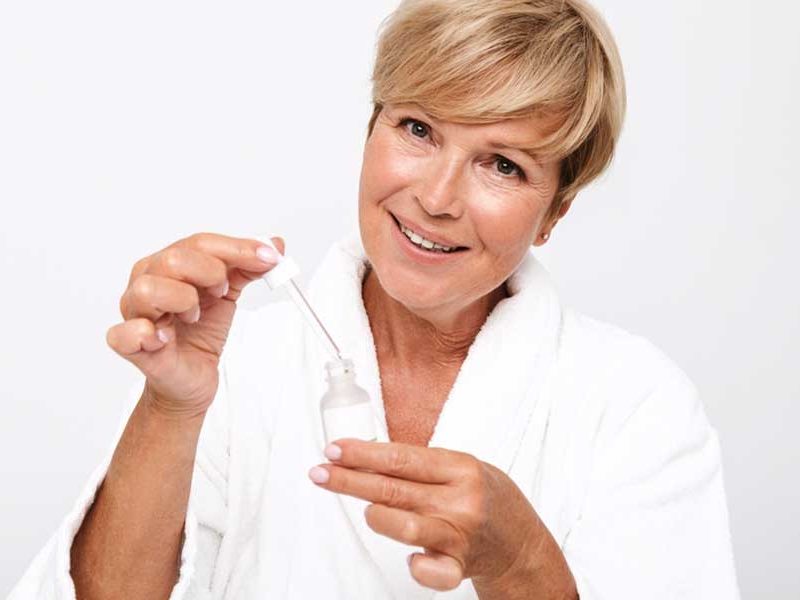 mujer aplicando un sérum para pieles maduras